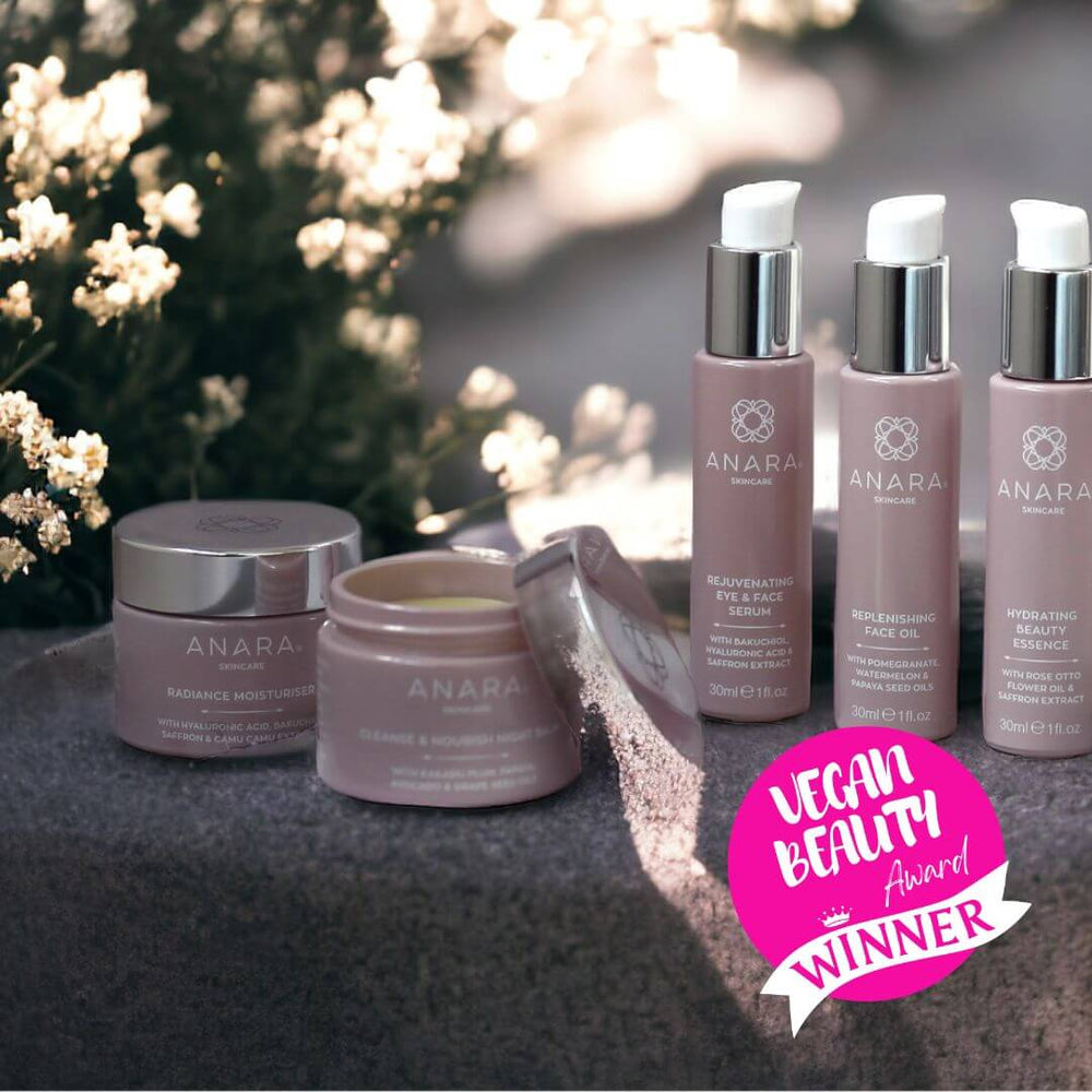The Anara Skincare range outside surrounded by sunlight and white flowers with the Vegan Beauty Award winner logo.