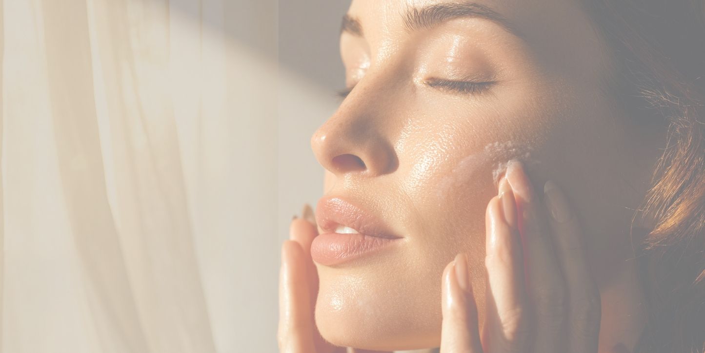 Lasy with eyes closed applying skincare by the window