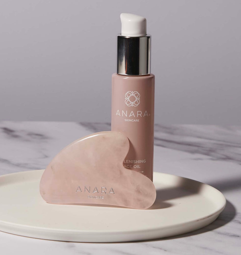 Anara Skincare Replenishing Face Oil and Rose Quartz Gua Sha standing on a white plate