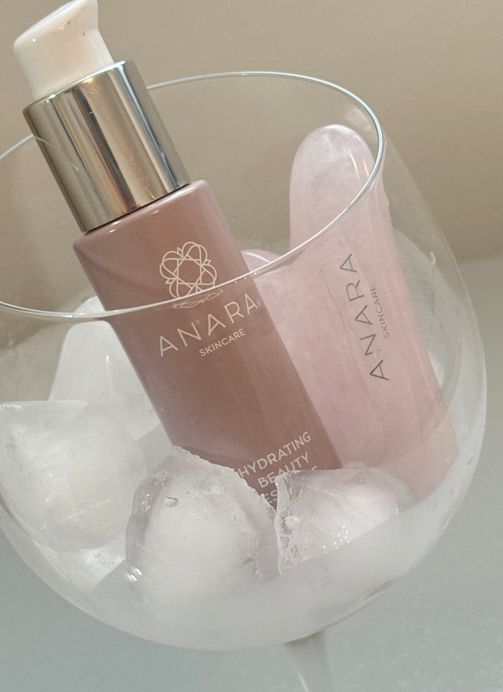 Anara Hydrating Beauty Essence and Rose Quartz Gua Sha in a glass filled with ice