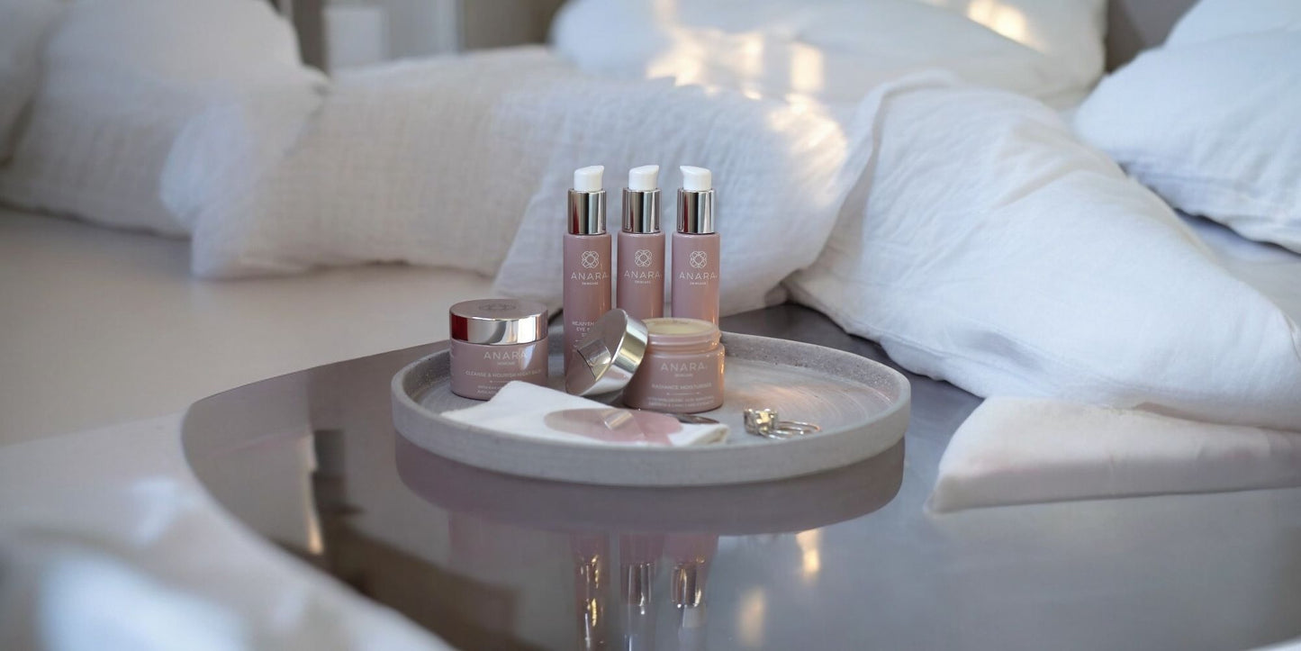 Anara Skincare products on a tray with white bedding in the background