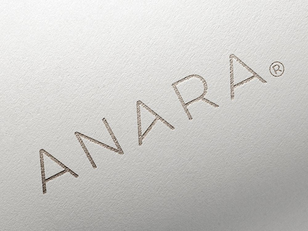 Close-up of 'ANARA' logo on a textured silver background