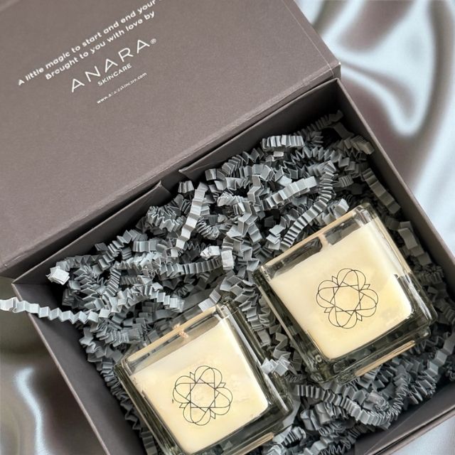 Two Anara Skincare square candles inside a gift box