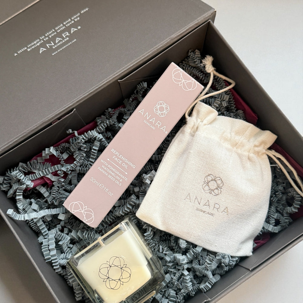 Anara Your Moment Candle, Replenishing Face Oil in carton and Rose Quartz Gua Sha pouch in gift box