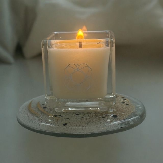 
                  
                    Lit Anara Skincare square candle on round Eratini fused glass plate
                  
                