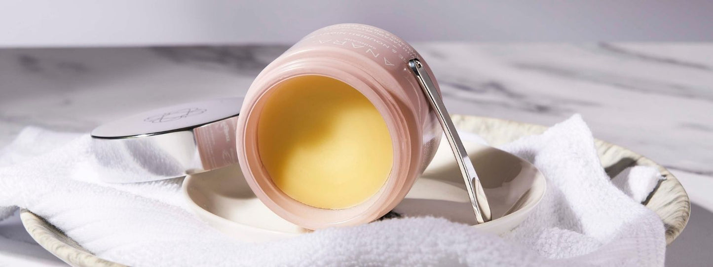 Cleanse & Nourish Night Balm on its side on a plate and white material