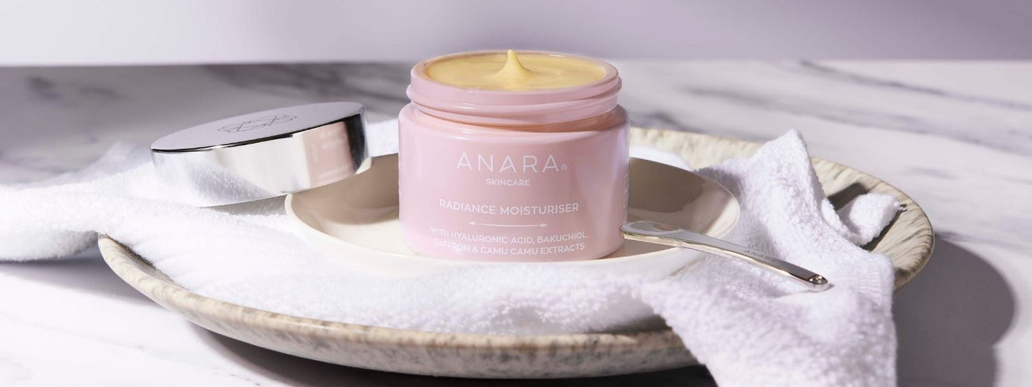 Anara Radiance Moisturiser with lid off on a plate and white towel