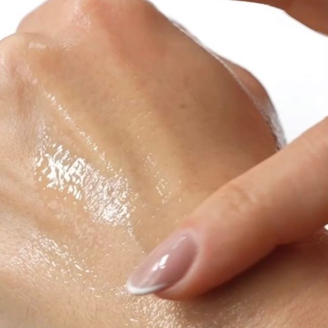 Anara Skincare Rejuvenating Eye & Face Serum on the back of a hand with finger sweeping it