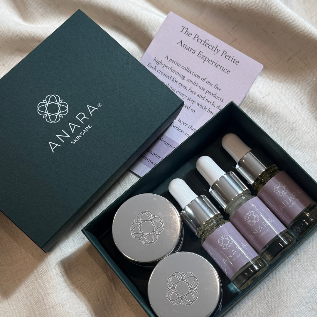 
                  
                    An open dark green ANARA skincare gift box containing the Anara range of 5 products in small sizes.
                  
                